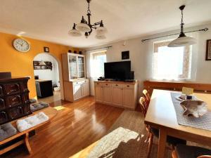 a living room with a dining table and a tv at House Pucnk-beautiful countryside in Železniki