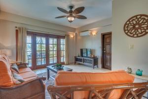 a living room with a couch and a ceiling fan at Placencia Pointe Townhomes #8 in Placencia Village