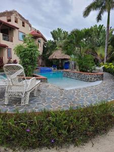 a resort with a swimming pool and two chairs at Placencia Pointe Townhomes #8 in Placencia Village