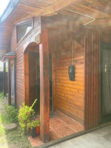 eine Außenseite eines Holzgebäudes mit einer Tür in der Unterkunft Acogedora casa céntrica en Panguipulli in Panguipulli