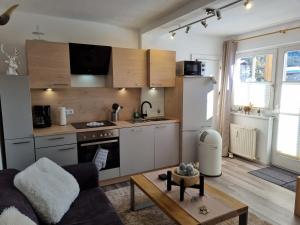 uma cozinha com um sofá e uma mesa num quarto em Appartement Bergsee SUN - direkt am See - Sonnenbalkon em Seefeld in Tirol