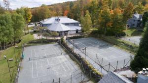 eine Luftansicht von zwei Tennisplätzen vor einem Haus in der Unterkunft The Woods by Killington Vacation Rentals - 2 Bedrooms in Killington