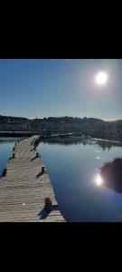 ein Dock auf einem Wasserkörper mit der Sonne am Himmel in der Unterkunft La VIA des Etangs in Peyriac-de-Mer