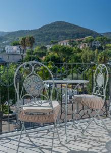 two chairs and a table on a balcony at Alloggio nuovissimo al centro e rilassante in Ischia