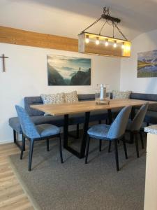 a dining room with a wooden table and blue chairs at Chalet 1480 in Gaschurn