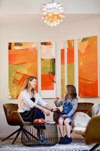 a woman and a little girl sitting on a table at Sojourn Apartment Hotel - Ghuznee in Wellington +36 photos