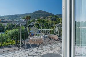 a balcony with chairs and a view of a mountain at Delphi Soggiorni Romantic Suites with Private Terrace - Ischia Porto in Ischia Town