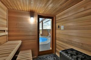a sauna with a tub and a window in it at Fall Line Condos by Killington VR - 2 Bedrooms in Killington