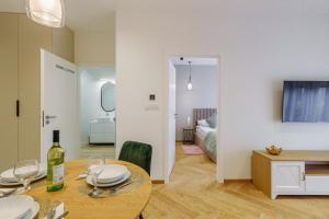 a room with a dining table and a bedroom at KORNWALIA - stylowy apartament o wysokim standardzie w centrum Nowego Targu, z prywatnym, zadaszonym parkingiem in Nowy Targ