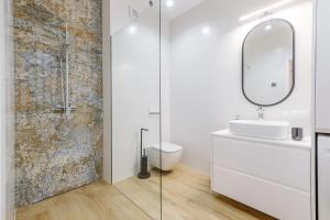 a bathroom with a toilet and a sink and a mirror at KORNWALIA - stylowy apartament o wysokim standardzie w centrum Nowego Targu, z prywatnym, zadaszonym parkingiem in Nowy Targ