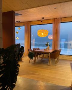 une salle à manger avec une table et une grande fenêtre dans l'établissement Ekkerøy Lodge - Arctic luxury, à Vadsø