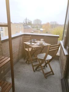 Gezellig appartement in Brugge, nabij Damme. في بروج: طاولة صغيرة وكراسي على شرفة