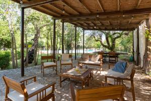 un patio con mesas y sillas de madera bajo un pabellón en Agriturismo Terra Di Pace, en Noto