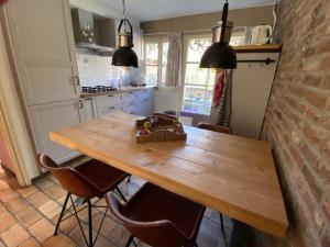 een keuken met een houten tafel en een aantal stoelen bij Holiday home Elena in Slenaken