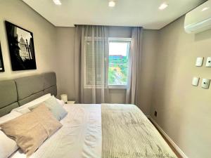 a bedroom with a large bed with a window at Flat 2 quartos a 2 quadras da paulista com garagem in São Paulo