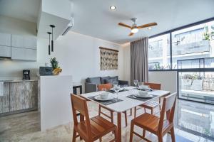 cocina y comedor con mesa y sillas en Incredible Luxury Tulum Penthouse with Large Private Pool in Aldea Zama, en Tulum