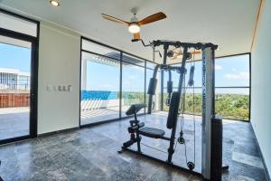 a gym with a treadmill and large windows at Incredible Luxury Tulum Penthouse with Large Private Pool in Aldea Zama in Tulum