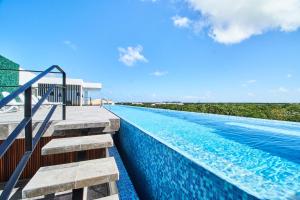 a swimming pool with stairs leading to a resort at Incredible Luxury Tulum Penthouse with Large Private Pool in Aldea Zama in Tulum