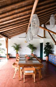 einen Holztisch und Stühle auf einer Terrasse mit Kronleuchtern in der Unterkunft Hacienda Bambusa in El Caimo