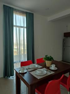 a dining room table with red chairs and a window at LOMAS AEROPUERTO in San Agustin de las Juntas