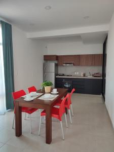 eine Küche mit einem Holztisch und roten Stühlen in der Unterkunft LOMAS AEROPUERTO in San Agustin de las Juntas