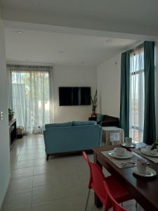 ein Wohnzimmer mit einem blauen Sofa und einem Tisch in der Unterkunft LOMAS AEROPUERTO in San Agustin de las Juntas