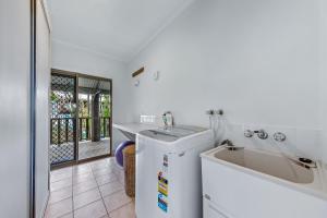 a white kitchen with a sink and a dishwasher at Family Resort in Great location! in Airlie Beach