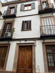a white building with wooden doors and windows at La casita de San Andrés in Seville
