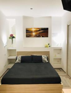 ein Schlafzimmer mit einem großen Bett in einem Zimmer in der Unterkunft appartamento per mare o centro storico di Roma in Lido di Ostia