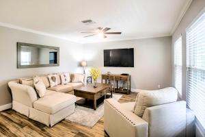 a living room with white furniture and a flat screen tv at Naples Home with Lanai and Pool Near Vanderbilt Beach! in Naples