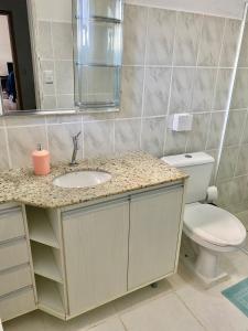 La salle de bains est pourvue d'un lavabo et de toilettes. dans l'établissement Red House - Casa com Linda vista do Mar, à Palhoça
