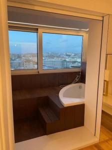 a bathroom with a bath tub and a window at MH by MGM - Premium Sea Views in Porto