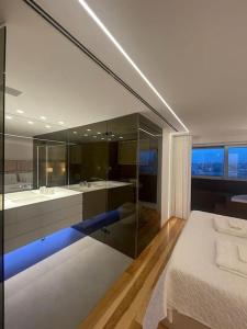 een slaapkamer met een bed en een badkamer met een bad bij MH by MGM - Premium Sea Views in Porto