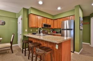 a kitchen with green walls and a stainless steel refrigerator at The Pico Escape- 3BR 2BA Ski On Ski Off at Pico Mountain, Close to Killington, condo in Killington