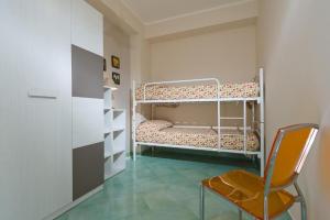 a small room with a bunk bed and a chair at Appartamenti il Patio in San Vito lo Capo