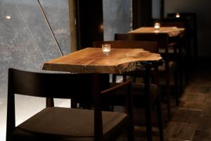 a wooden table and chairs with a glass on it at Country Inn Milky House in Niseko