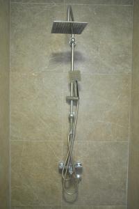 eine Dusche mit Duschkopf im Bad in der Unterkunft West in apartments in Čačak