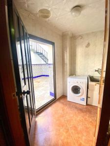 een wasruimte met een wasmachine en een trap bij Casa Cruz de Marbella in Luque