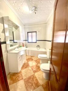 een badkamer met 2 toiletten, een wastafel en een douche bij Casa Cruz de Marbella in Luque