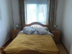 a bedroom with a bed and a window with curtains at Moville Centre Apartment in Moville