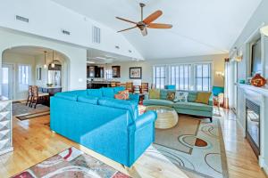a living room with a blue couch and a fireplace at Gone Coastal 139 in Rodanthe
