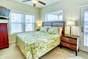 a bedroom with a bed and a tv and windows at Gone Coastal 139 in Rodanthe