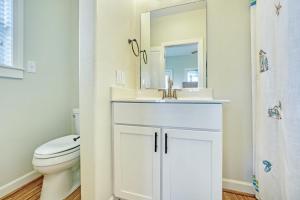 a bathroom with a sink and a toilet and a mirror at Gone Coastal 139 in Rodanthe +29 photos