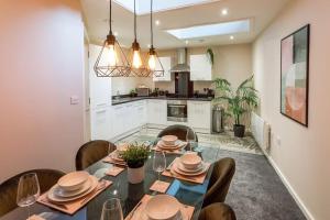 a dining room with a table and chairs and a kitchen at Stylish Duplex 5 min from centre in Newcastle upon Tyne