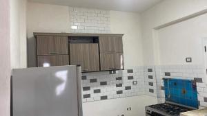 a kitchen with brown cabinets and a refrigerator at فيلا محمد بدر in Alexandria