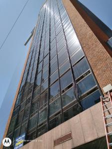 un edificio alto con ventanas de cristal en el lateral. en APART OBELISCO en Buenos Aires