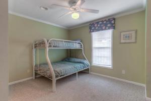 een slaapkamer met een stapelbed in een kamer met een plafondventilator bij Windward in Carolina Beach