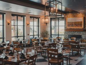 a dining room with tables and chairs and windows at Sagecliffe Resort & Spa in George