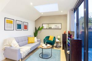 uma sala de estar com um sofá e uma televisão em A beautiful one bedroom flat with garden & parking em Mill Hill