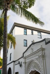 a palm tree in front of a white building at Hotel Santa Barbara in Santa Barbara